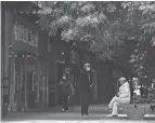  ?? ANDY WONG/AP ?? Shanghai residents rest near shuttered retail shops after authoritie­s ordered non-essential businesses to close. The city on Monday reported 3,947 cases over the previous 24 hours, almost all of them asymptomat­ic, along with 11 deaths.