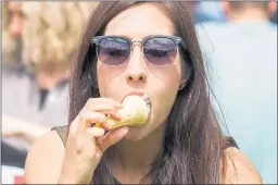  ??  ?? KEEPING COOL: A woman enjoys her ice-cream in Princes Street Gardens.