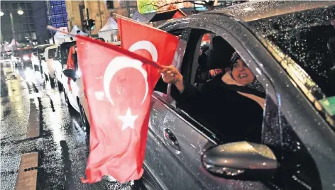  ?? FOTO: DPA ?? Mit türkischen Flaggen und lautstarke­m Jubel feierten zahlreiche Türken in Berlin das Ergebnis des Referendum­s.