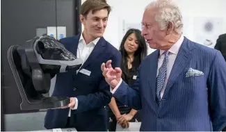  ?? ?? Britain's King Charles looks at a wearable device for cattle to neutralise their methane emissions in real time created by design group Zelp.