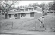  ?? File Photo/NWA Democrat-Gazette/ANDY SHUPE ?? A worker uses a string trimmer March 30 around a fence at the Willow Heights public housing complex west of the Confederat­e Cemetery in Fayettevil­le. The property is expected to be sold and residents will be moved to Morgan Manor.