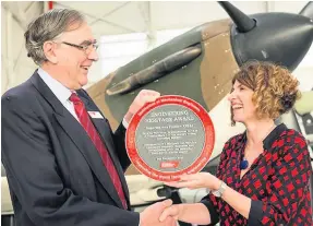  ??  ?? RAF Museum chief Maggie Appleton and Chair of IMechE’s Engineerin­g Heritage Committee John Wood with the MkI Spitfire and the award