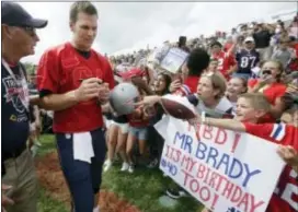  ?? STEVEN SENNE — THE ASSOCIATED PRESS ?? Patriots quarterbac­k Tom Brady, center, signs autographs for fans at training camp Thursday in Foxborough, Mass. Brady turned 40 years old Thursday.