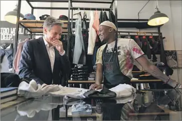  ?? Andrew Harnik Pool Photo ?? U.S. SECRETARY OF STATE Antony J. Blinken shares a joke with clothing designer Tshepo on Sunday in Johannesbu­rg. Blinken will visit the Democratic Republic of Congo and Rwanda later this week.