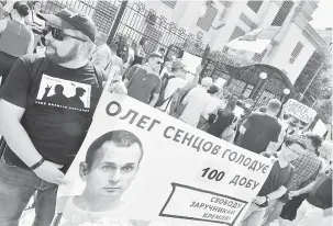  ?? — Gambar Genya Savilov/AFP ?? BEBASKAN SENTSOV: Penunjuk perasaan memegang poster yang bertulis‘Bebaskan Sentsov’semasa demonstras­i di hadapan kedutaan Rusia di ibu negara Ukraine, Kiev, kelmarin.