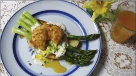  ?? SARA MOULTON VIA AP ?? This April 2017 photo shows roasted asparagus toast with a fried poached egg in New York. The base is artisanal toast brushed with olive oil and topped with roasted asparagus. The asparagus can be prepped and pre-roasted and then warmed in the oven...