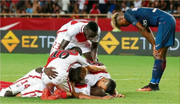  ??  ?? Heap, heap, hooray: Monaco’s Djibril sidibe is mobbed by team-mates after scoring against Paris st Germain at the stade Louis II on sunday. — EPA