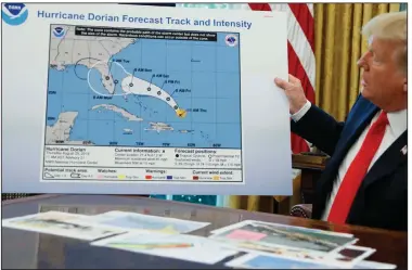  ?? (AP/Evan Vucci) ?? President Donald Trump holds a chart with a doctored forecast track for Hurricane Dorian as he talks with reporters on Sept. 24.