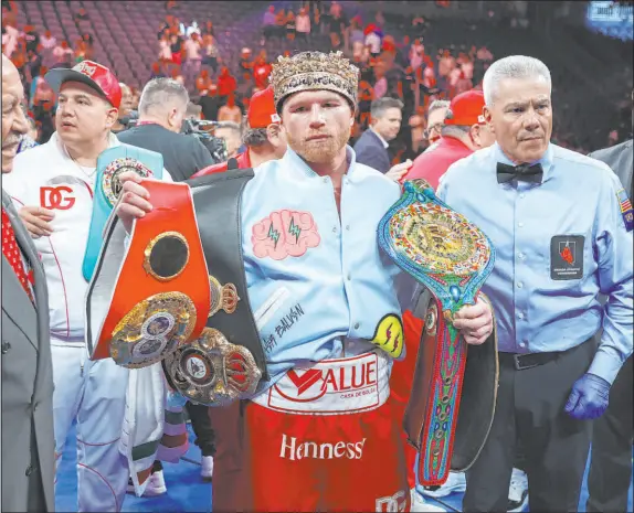 ?? ?? Saul “Canelo” Alvarez (58-2-2, 39 knockouts) poses with his super middleweig­ht title belts and a ceremonial crown after scoring a unanimous decision over Gennady Golovkin (42-2-1, 37 KOS) in the third fight of their epic trilogy Saturday night at T-mobile Arena.
