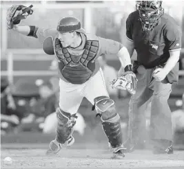  ?? ROBERT DUYOS/SUN SENTINEL ?? Dodgers: Miami catcher Yasmani Grandal rips off his mask to field a ground ball during a home game against FAU in 2010.