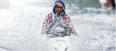  ?? Reuters ?? ↑
A man rides a scooter through a waterlogge­d-road after rains in Mumbai on Thursday.