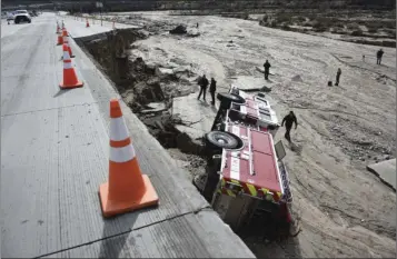  ?? AP PHOTO ?? In this Feb. 18 file photo, officials look over the scene at Interstate 15 in the Cajon Pass where part of the freeway collapsed due to heavy rain.