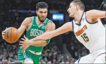  ?? Michael Dwyer The Associated Press ?? Celtics forward Jayson Tatum tries to drive against Nuggets forward Nikola Jokic in the first half of Boston’s 108-102 win Friday at TD Garden. Tatum had 24 points.