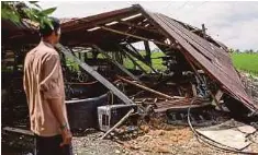  ?? ?? A man checking a barn damaged during the storm yesterday.