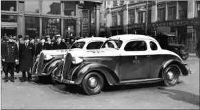  ?? WIDE WORLD PHOTOS/THE NEW YORK TIMES ?? NYPD officers show off their new patrol cars in New York on March 22, 1938. The cars were brightly painted to make them more conspicuou­s to motorists and others while conducting police work.