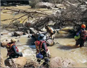  ?? (AP Photo) ?? A search and rescue team looks for bodies Tuesday at Umzinyathi Falls after floods in Inanda near Durban.