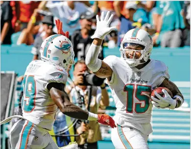  ??  ?? Dolphins receiver Jakeem Grant (left) high-fives Albert Wilson as Wilson scores to seal a victory over the Raiders this season. Both players possess noteworthy speed, which can lead to explosive plays.