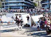  ??  ?? Durant la traversée de la plage, le public s’était massé sur le bord de mer surplomban­t le défilé.