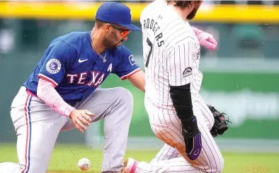  ?? (AP photo/david Zalubowski) ?? Texas Rangers second baseman Marcus Semien, left, mishandles a throw as Colorado Rockies' Brendan Rodgers, right, steals second base Sunday during a baseball game in Denver.