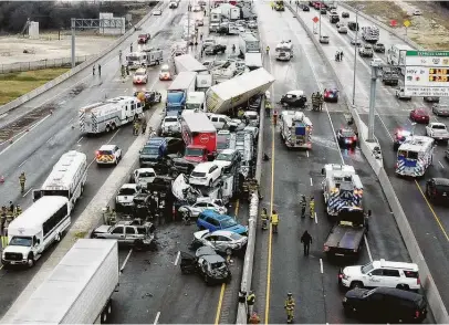  ?? Lawrence Jenkins / Dallas Morning News ?? First responders work the scene of a massive pileup of more than 130 vehicles near Fort Worth on Thursday. At least six people were killed and dozens were hurt in the crash as snow, freezing rain and sleet led to dangerous road conditions in parts of Texas.