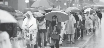  ?? SEAN KILPATRICK/THE CANADIAN PRESS ?? People line up in the rain for the Canada 150 celebratio­ns in 2017. Beefed-up security led to long waits to get onto Parliament Hill.