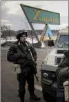  ?? EVGENIY MALOLETKA — AP ?? A Ukrainian National guard soldier guard a mobile checkpoint together with the Ukrainian Security Service agents and police officers in Kharkiv, Ukraine, on Thursday.
