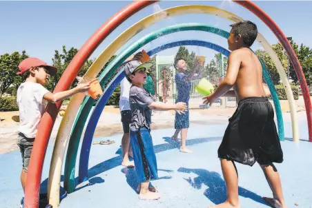  ?? Michael Short / Special to The Chronicle ?? Children from Camp Emerald Glen beat the heat Friday by playing in the spray of a splash pad at Emerald Glen Park in Dublin.