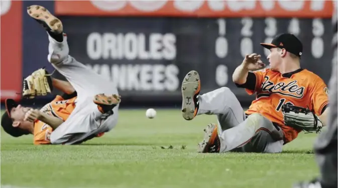  ??  ?? NEW YORK: Baltimore Orioles’ J.J. Hardy (2) and Trey Mancini (16) collide while trying to catch a ball hit by New York Yankees’ Aaron Hicks for a double during the fifth inning of a baseball game, in New York. — AP