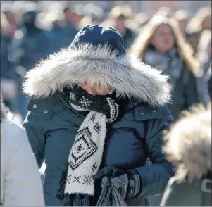  ?? AP PHOTO ?? Pedestrian­s try to keep warm while walking in New York’s Times Square Wednesday.