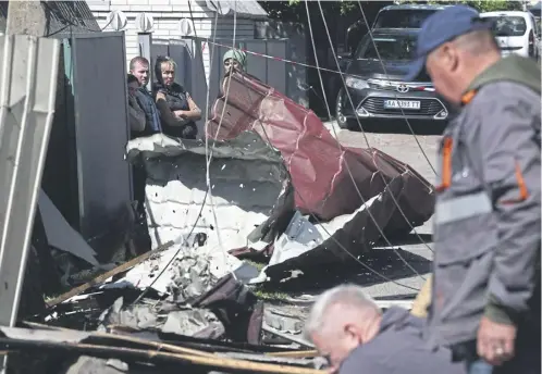  ?? ?? Ukrainians survey the damage from a attack in Krasylivka in the Kyiv region. Volodymyr Zelensky, below, comdemned ‘massive’ attacks