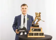 ??  ?? Kale Clague with the Bill Hunter Memorial Trophy, presented to the Western Hockey League’s defenceman of the year, at the recent WHL Awards Banquet.