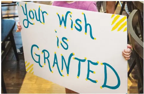  ?? Associated Press ?? In this Aug. 22, 2019, photo, a girl holds a sign while waiting for her cousin to arrive for a surprise Make-A-Wish announceme­nt in Rogers, Ark. The Makea-Wish Foundation is disputing what it calls a “misinforma­tion” campaign about whether children who aren’t vaccinated against COVID-19 will be eligible to have their wishes granted.