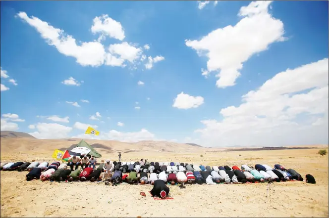  ?? (AP) ?? Palestinia­ns pray during a protest against Israel’s plan to annex parts of the West Bank and Trump’s Mideast initiative, in Jordan Valley on June 19.