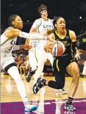  ?? Ronald Martinez Getty Images ?? CHENNEDY CARTER , who scored 10 points for the Sparks, controls the ball against the Minnesota Lynx’s Aerial Powers (3) in the first quarter.