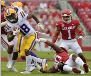  ?? (AP/Michael Woods) ?? LSU running back Chris Curry (18) spins away from Arkansas defensive lineman Marcus Miller (90) during the first half Saturday. Positive covid-19 tests and contact tracing took its toll on UA’s defensive line, with just two players who had significan­t playing experience competing.