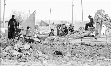  ??  ?? An Iraqi family sits on the rubble of their home in the village of Barzan, in the Zummar area of Nineveh province, northwest of Mosul.— AFP photo