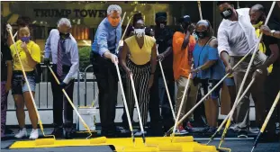  ?? MARK LENNIHAN THE ASSOCIATED PRESS ?? Mayor Bill de Blasio, third from the left, participat­es in painting Black Lives Matter on Fifth Avenue in front of Trump Tower on Thursday in New York. The Rev. Al Sharpton is second from the left.
