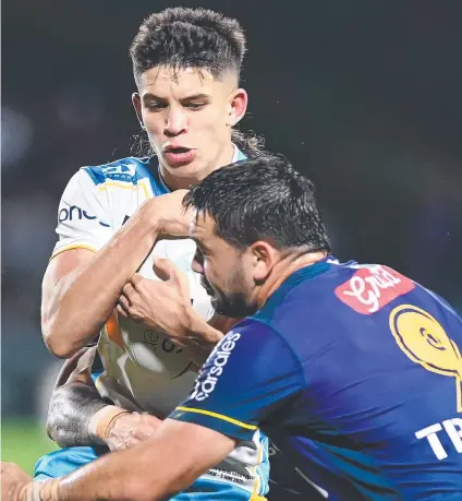  ??  ?? Gold Coast’s Jayden Campbell is tackled by Melbourne’s Brandon Smith. Campbell had an impressive debut in his team’s defeat to the reigning premiers. Picture: Bradley Kanaris/Getty Images