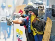  ?? THE ASSOCIATED PRESS ?? Anti-government protesters face off against security forces blocking them from marching to the Supreme Court in Caracas, Venezuela, on Saturday.