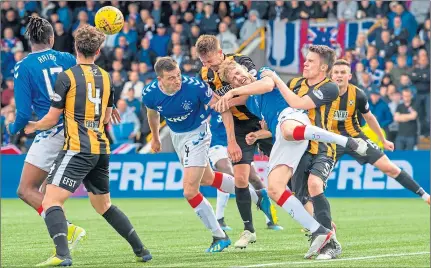  ??  ?? Chris Higgins (centre) takes time off from his role as PFA Scotland’s personal developmen­t officer by trying to thwart Rangers’ George Edmundson and Filip Helander when they visited East Fife in the Betfred Cup