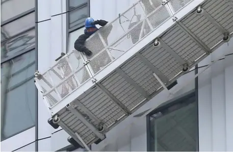  ?? MATT sTOnE pHOTOs / HErAld sTAFF ?? TO SAFETY: Two window washers were rescued from their platform outside the 42nd floor of The Sudbury in Boston on Thursday.