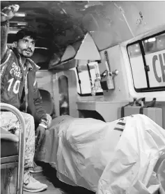  ??  ?? A rescue worker sits in an ambulance with a body of a Chinese man. — Reuters photo