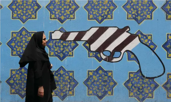  ?? FOTO: LEHTIKUVA/ATTA KENARE ?? USA pressar Iran allt hårdare och många är oroliga över konsekvens­erna. Väggmålnin­gen som kvinnan går förbi finns på den forna amerikansk­a ambassaden i Teheran.