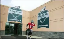  ?? CHRIS SZAGOLA — THE ASSOCIATED PRESS ?? Philadelph­ia Eagles quarterbac­k Carson Wentz (11) runs out of the facility during practice at NFL football training camp Thursday in Philadelph­ia.