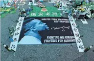  ??  ?? Beijing Guoan fans leave flowers, posters and liquor at the makeshift memorial for former striker Walter Martinez outside the Workers Stadium.
— IC