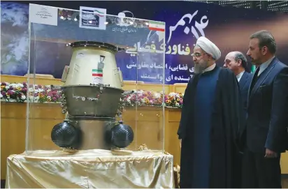 ?? (Reuters) ?? IRAN PRESIDENT Hassan Rouhani looks at an exhibit during a ceremony marking National Day of Space Technology in Tehran yesterday.