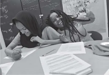 ?? Helen H. Richardson, The Denver Post ?? Fifteen-year-old Mary Getachew, right, laughs with her mentor, Sabrin Mohamed, 18, as the two take part in YESS Institute class at North High School.