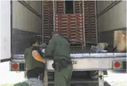  ?? Delcia Lopez / (McAllen, Texas) Monitor ?? Border Patrol officers check the tractor-trailer in Edinburg, Texas, where the migrants were found.