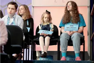  ?? AP Photo/Jacquelyn Martin ?? Edith Fuller, 6, of Tulsa, Okla., center, the youngest speller ever in the National Bee, sits next to Marlene Schaff, 14, of Lake Forest, Ill., right, as they wait to compete in the 90th Scripps National Spelling Bee on Wednesday in Oxon Hill, Md.