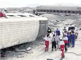  ?? Iranian Red Crescent Society via AP ?? Rescuers work at the scene where a passenger train partially derailed near the desert city of Tabas in eastern Iran, on Wednesday. Authoritie­s say at least 22 people were killed.